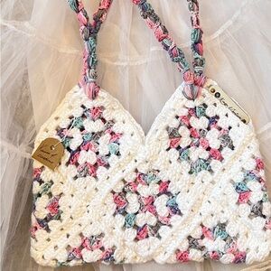Handcrafted Crochet Bag with white, shades of pink, blue and purple Design.